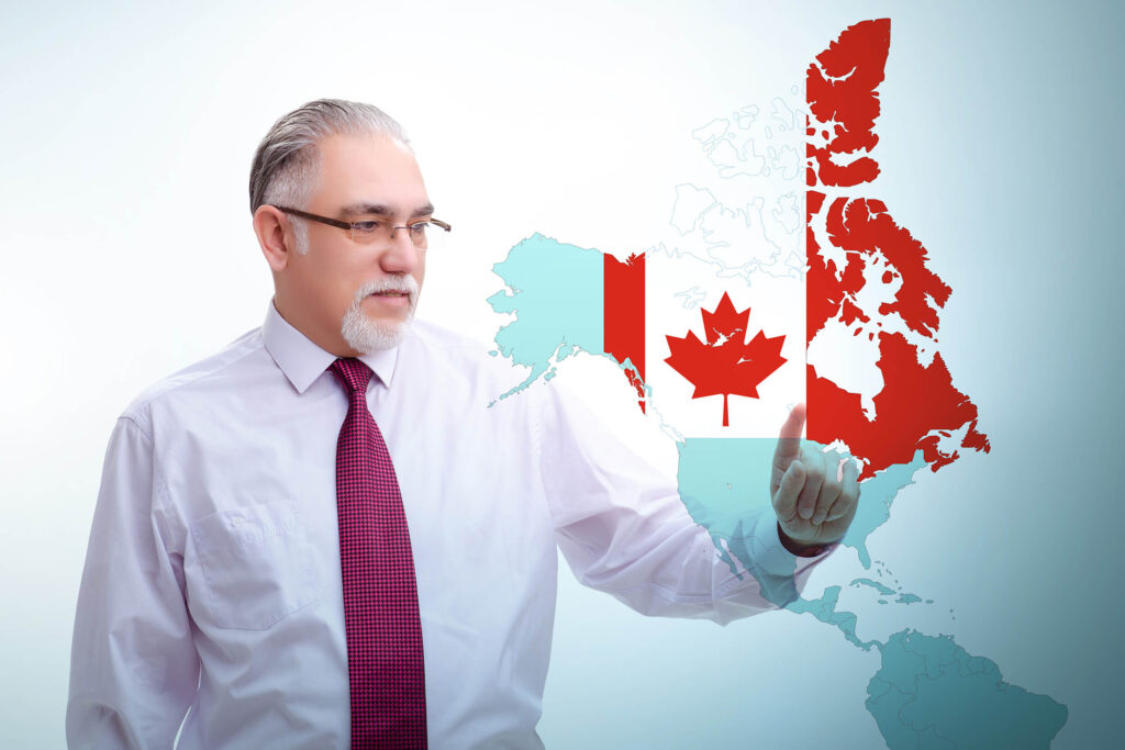 Executivo de camisa social manga longa, gravata e óculos apontando para um mapa virtual da América do Norte com o Canadá destacado com as cores da sua bandeira.